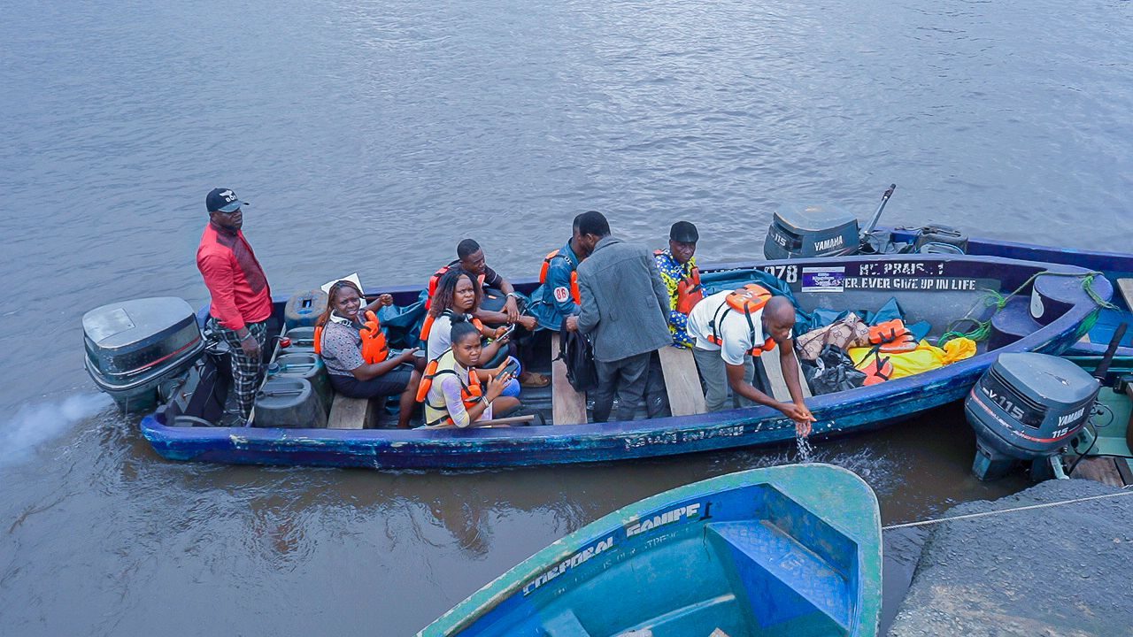 Team travelling by boat to a riverside community