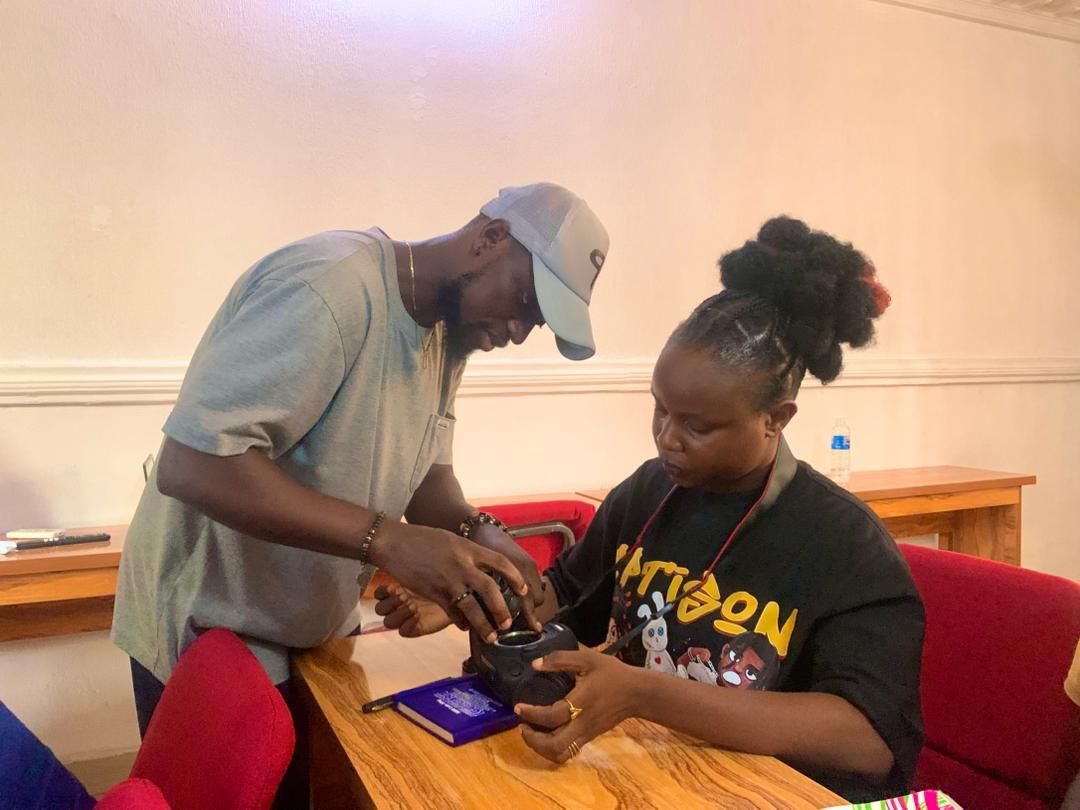 A facilitator teaching a participant to use a camera