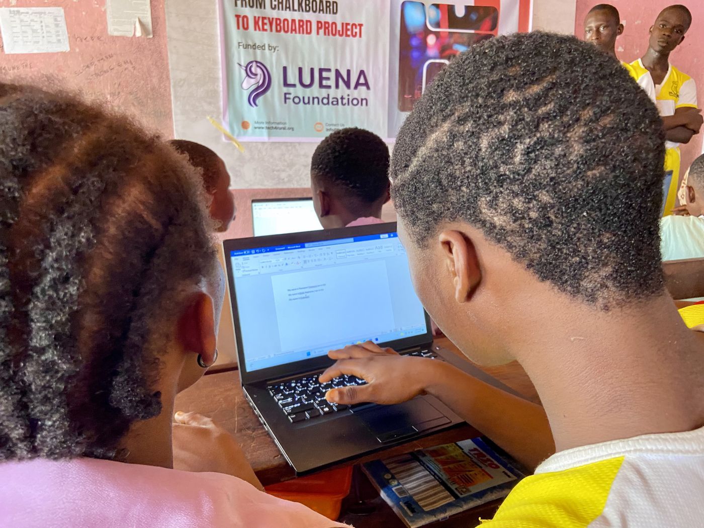 A student typing on a donated laptop